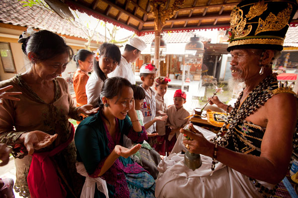 A priest is giving holy water to the worshippers